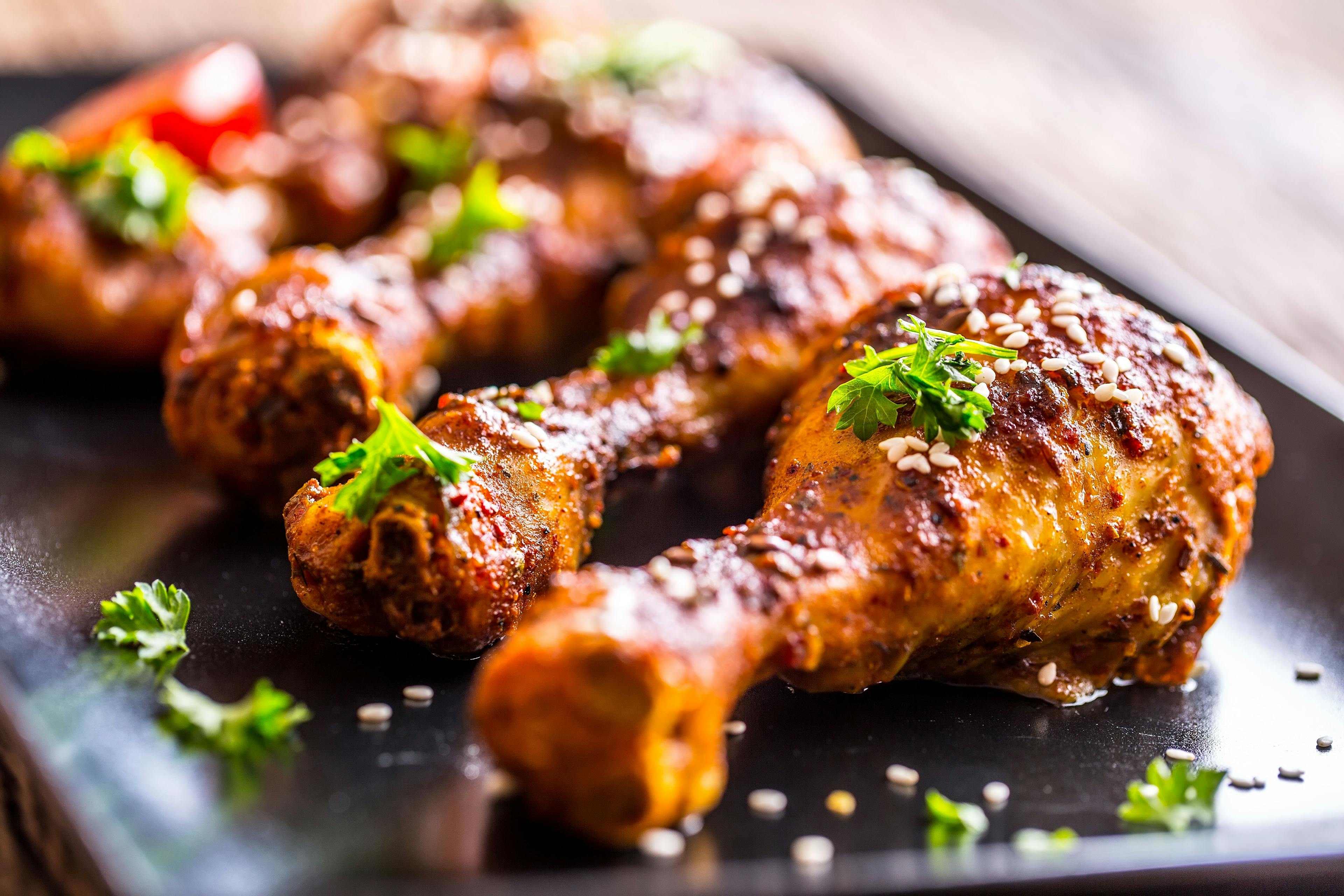 Grilled chicken legs. Grilled chicken legs BBQ with sesame parsley and tomato. | Image Credit: © weyo - stock.adobe.com