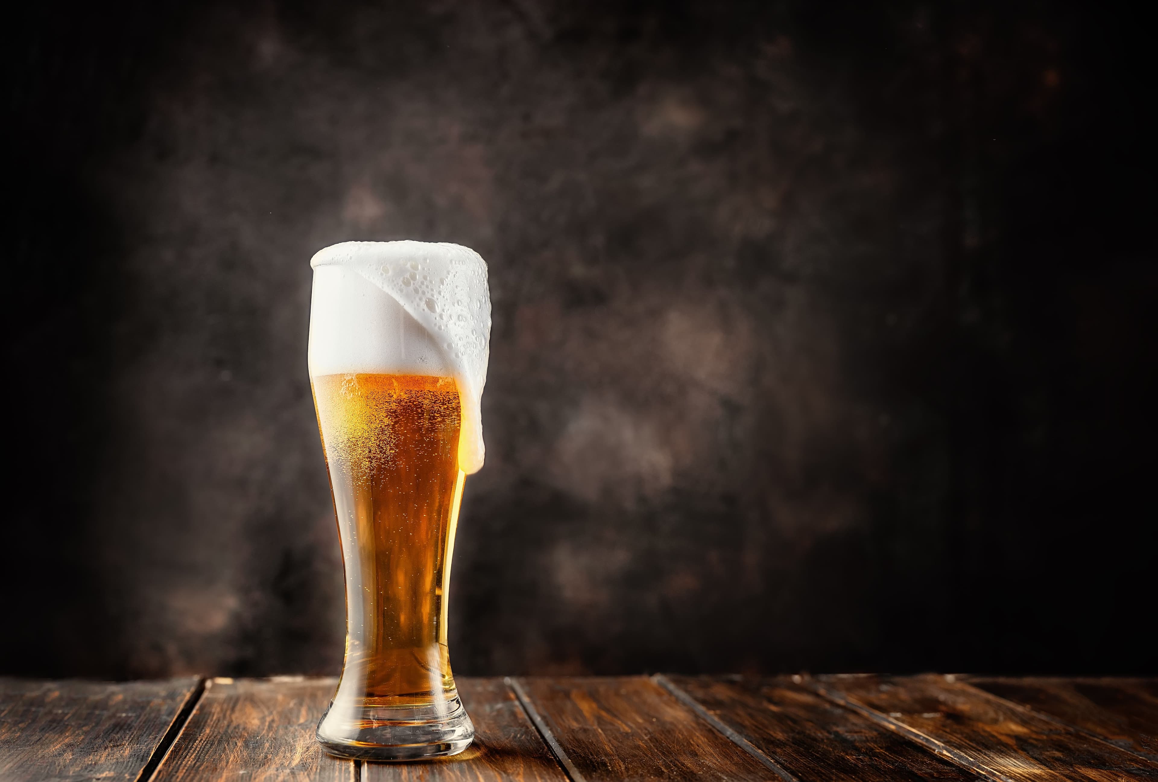 Glass of fresh and cold beer on dark background. | Image Credit: © Katecat - stock.adobe.com