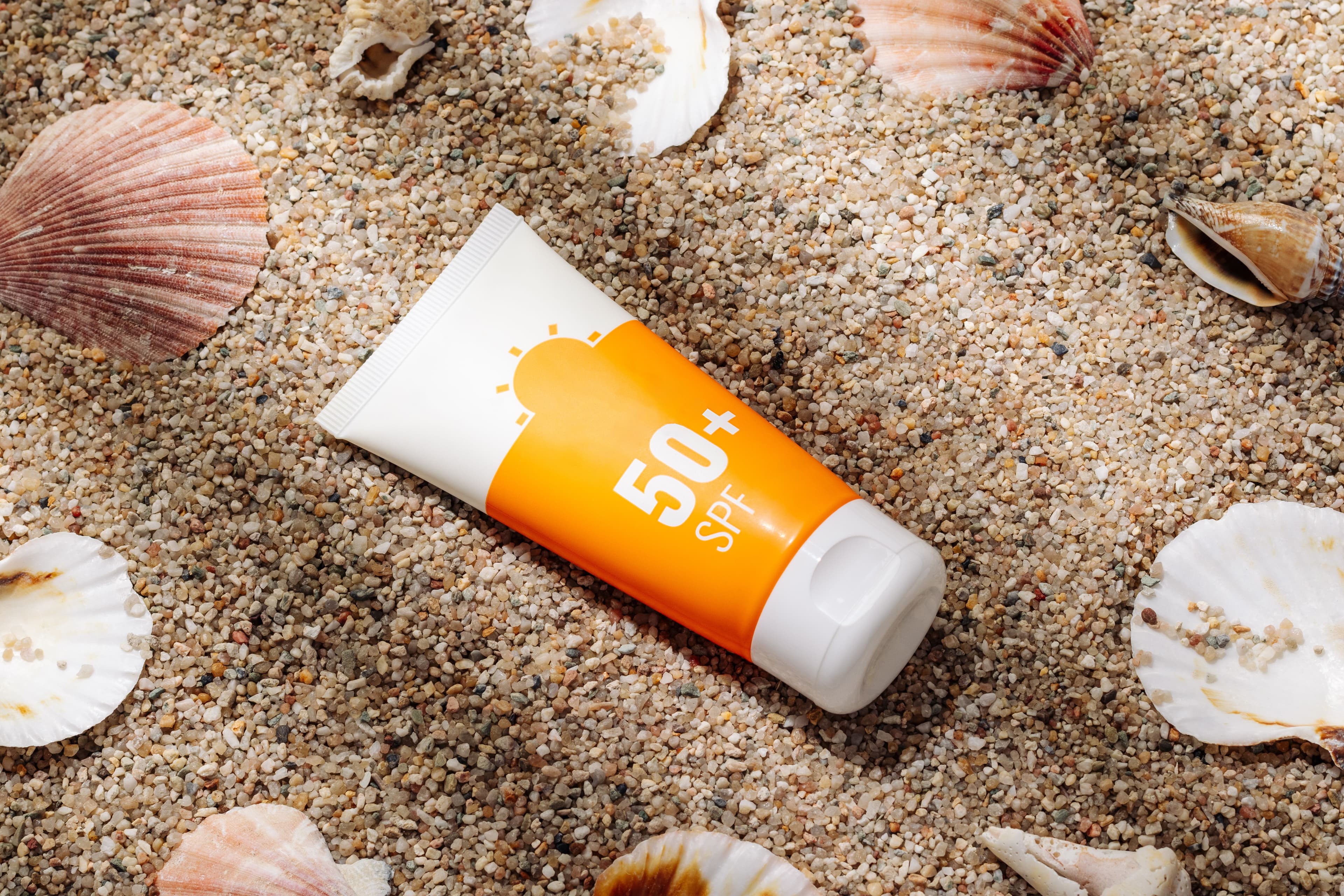 Orange tube of sunscreen on sandy beach top view | Image Credit: © Ольга Голубева - stock.adobe.com