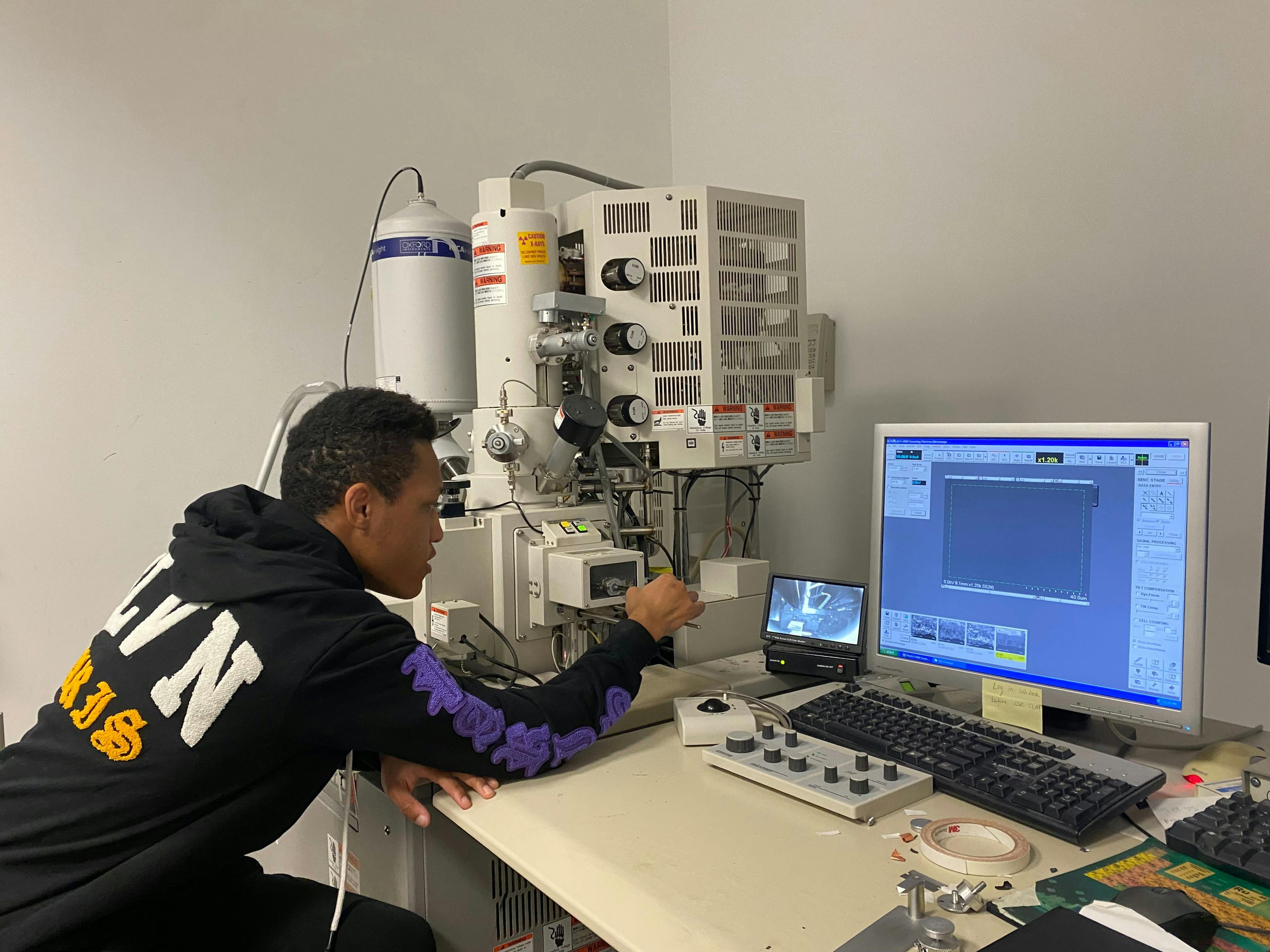 An undergraduate research student Jaylen Buckner, in the Eigenbrodt Research laboratory, conducting scanning electron microscopy measurement on 3D printed fuel cell electrode catalysts | Photo Credit: © Bryan Eigenbrodt